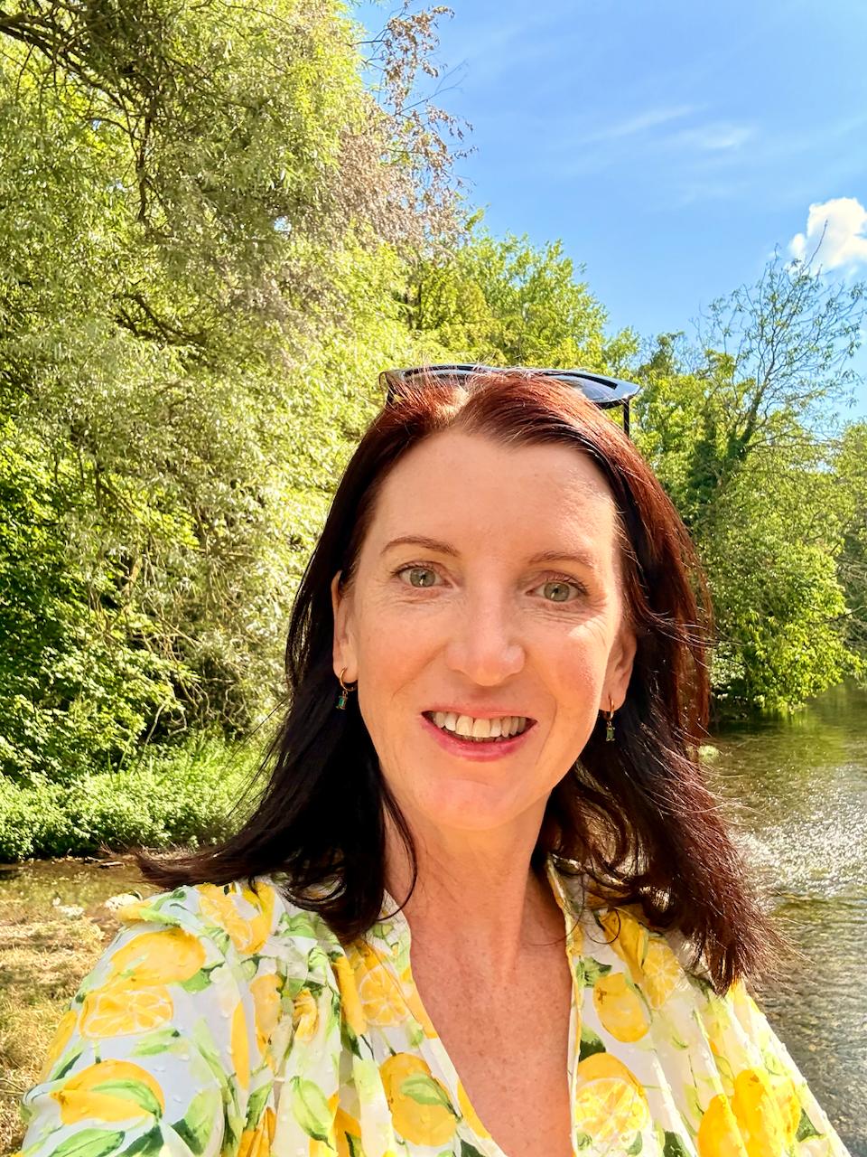 Merilyn Bullen smiling beside a tree-lined river